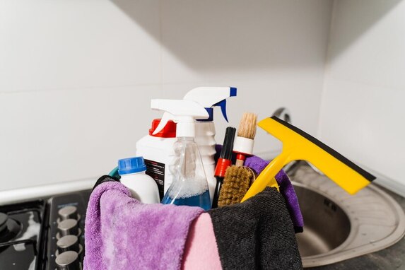 A professional cleaner using a microfiber rag and bucket for kitchen cleaning