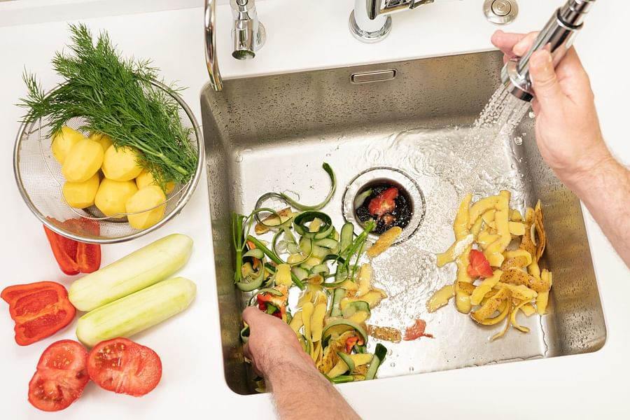 grinding citrus rinds in sink