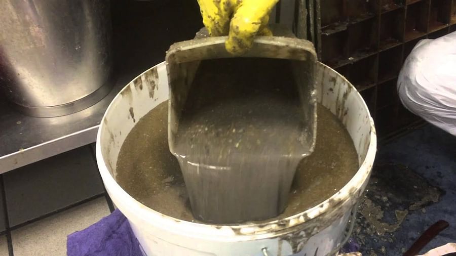 Person cleaning a grease trap as part of a DIY project